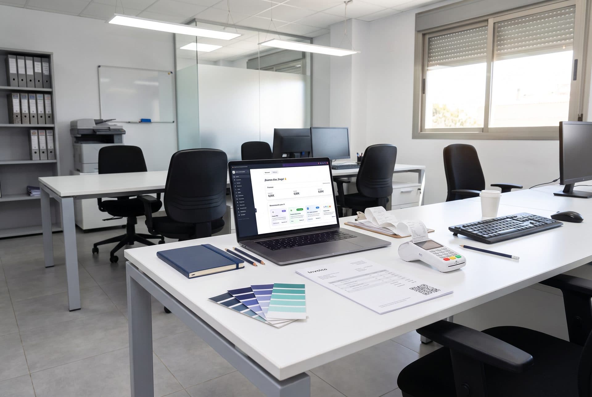 Portátil con el panel de Holded en la oficina de una empresa, junto a una factura impresa con su código QR de VeriFactu y un terminal de cobro